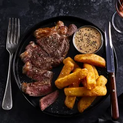 A plate of food with delicious looking steak and chips on.